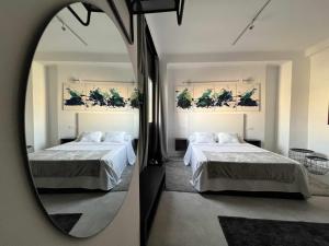 um quarto com 2 camas e um espelho em Eneldo modern & luxury em Málaga