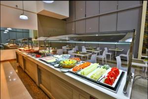 a buffet line in a restaurant with fruits and vegetables at Flat 1015 - Comfort Hotel Taguatinga in Brasilia