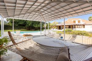 eine Terrasse mit Hängematte und ein Haus in der Unterkunft Il Giardino di Venere in Mondello