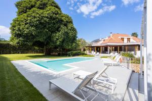 a swimming pool with lounge chairs next to a house at Il Giardino di Venere in Mondello