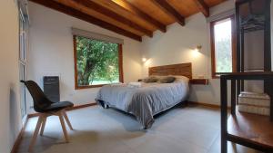 a bedroom with a bed with a stuffed animal on it at Alojamiento Chacra El Monje in El Hoyo