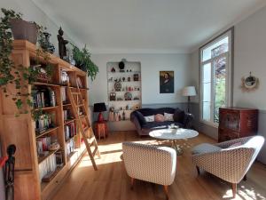 sala de estar con sofá y mesa en La Maucannière en Joue-les-Tours