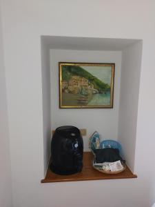 uma prateleira num quarto com uma fotografia na parede em Appartamento da Rossella em Maratea