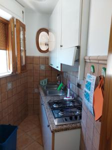 uma pequena cozinha com um fogão e um lavatório em Appartamento da Rossella em Maratea