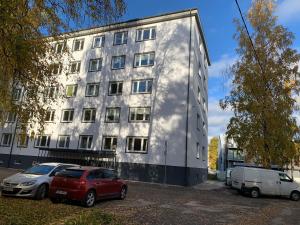 Un edificio con dos coches aparcados delante. en Uus 13b, Beautiful 3-bedroom Apartment - 3 big beds, en Tartu