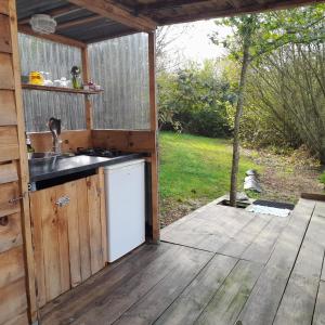 une cuisine extérieure avec un évier et une terrasse en bois dans l'établissement TENTE SAFARI LODGE DANS FORET LUXURIANTE, à Vielle-Tursan