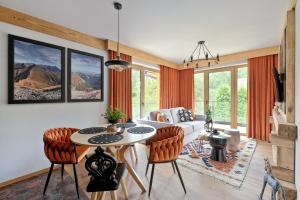 a living room with a table and chairs at Rezydencja Górska, Odkryj-Zakopane in Zakopane