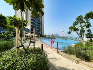 Aria Apartment Dubai Marina -Two Bedroom Apartment By Luxury Explorer's Collection في Dubai Marina: مسبح امام مبنى طويل