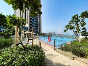 a swimming pool in front of a tall building at Aria Apartment Dubai Marina -Two Bedroom Apartment By Luxury Explorer's Collection in Dubai Marina