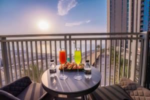 a table on a balcony with two drinks on it at Aria Apartment Dubai Marina -Two Bedroom Apartment By Luxury Explorer's Collection in Dubai Marina