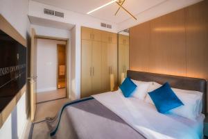 a bedroom with a large bed with blue pillows at Aria Apartment Dubai Marina -Two Bedroom Apartment By Luxury Explorer's Collection in Dubai Marina