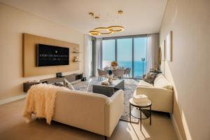 a living room with two couches and a television at Aria Apartment Dubai Marina -Two Bedroom Apartment By Luxury Explorer's Collection in Dubai Marina