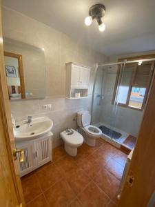 a bathroom with a toilet and a sink and a shower at Casa La Fontana Bronchales in Bronchales