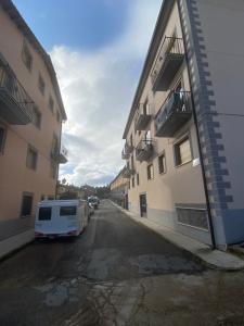 una furgoneta blanca estacionada en un estacionamiento junto a los edificios en Casa La Fontana Bronchales, en Bronchales