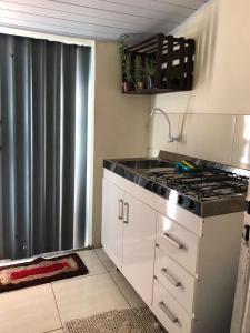 uma cozinha com um fogão e um lavatório em Recanto Magalhães em Barra do Garças