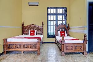 1 dormitorio con 2 camas y ventana en SPOT ON 91798 Hotel Grand Mutiara en Cikampek