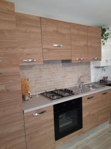 cocina con armarios de madera y horno con fogones en In Vino Veritas, en Sulmona