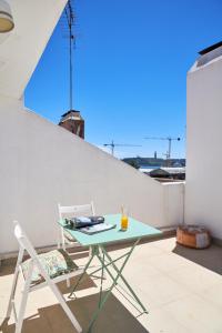 einen Tisch und einen Stuhl auf dem Balkon in der Unterkunft Sunny Apartment with Terrace.River view! in Lissabon