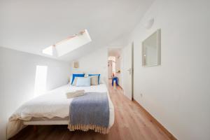 ein weißes Schlafzimmer mit einem großen Bett mit blauen Kissen in der Unterkunft Sunny Apartment with Terrace.River view! in Lissabon