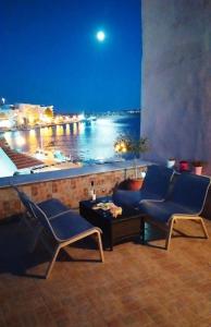 balcón con sillas y vistas al agua en Havenly Loft en Mitilene