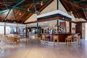 a bar in a restaurant with chairs and tables at PortBlue Club Pollentia Resort & Spa in Alcudia