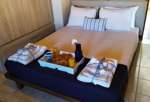 a bed with a tray of food and drinks on it at Havenly Loft in Mytilene
