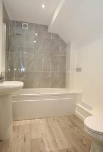 ein Badezimmer mit einer Badewanne, einem Waschbecken und einem WC in der Unterkunft Strand House Flat 2 Free Parking, by RentMyHouse in Exmouth