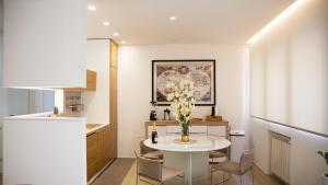 una cucina e una sala da pranzo con tavolo e sedie bianchi di Lux Apartment in Historical Center of Palermo a Palermo