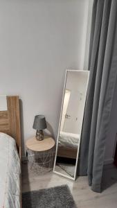 uno specchio in una camera da letto con un letto e un tavolo di Apartamento da Antónia a Viseu