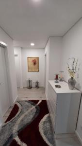 a white kitchen with a counter and a vase on a rug at Apartamento da Antónia in Viseu