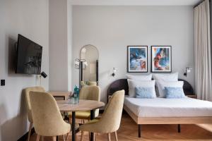 a bedroom with a bed and a table and chairs at numa I Novela Rooms & Apartments in Berlin