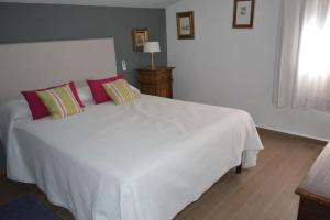 a bedroom with a white bed with red pillows at Fantastic Private Villa with pool near Ardales and Caminito del Rey in Ardales +31 photos