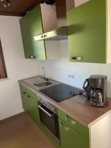 a kitchen with green cabinets and a sink at Bungalowdorf Lübben in Lübben