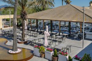 a patio area with tables, chairs and umbrellas at PortBlue Club Pollentia Resort & Spa in Alcudia
