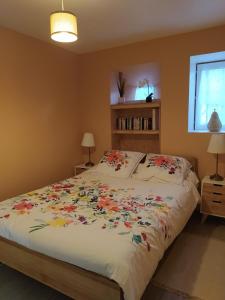 ein Schlafzimmer mit einem Bett mit Blumen darauf in der Unterkunft Suite au pied de la montagne et vue imprenable in Saint-Alban