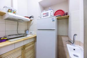 a small kitchen with a white refrigerator and a sink at Mini Hotel near Arena City in Kyiv