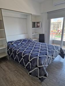 Schlafzimmer mit einem Bett mit blauer Decke in der Unterkunft Corazón de Flores in Buenos Aires