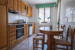 cocina con mesa de madera y mesa pequeña con sillas en casa apartamento en Riezu Mapi etxea, en Riezu