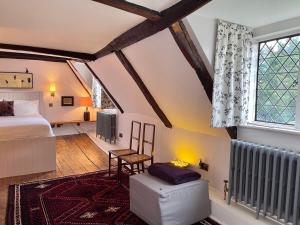 1 dormitorio en el ático con cama y ventana en Moat Farm House, en Ash