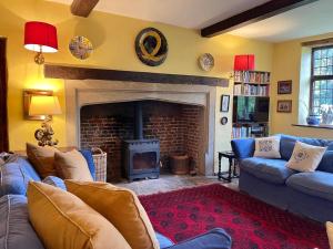 a living room with a couch and a fireplace at Moat Farm House in Ash