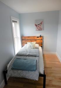 a bedroom with a bed with a wooden headboard and a window at The Loft in Lyndeborough