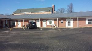 a car parked in a parking lot in front of a building at Savannah Motel in Savannah