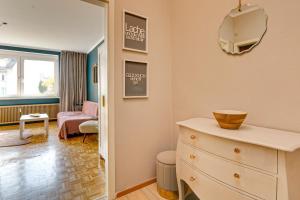 a room with a dresser and a living room at Schickes Boutique-Apartment, zentral in Messe-& Bahnhofsnähe, sehr ruhig & gratis Parkplatz - HappyStay in Klagenfurt