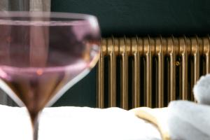 a glass of wine sitting next to a radiator at Schickes Boutique-Apartment, zentral in Messe-& Bahnhofsnähe, sehr ruhig & gratis Parkplatz - HappyStay in Klagenfurt