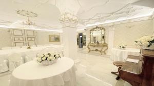 ein weißes Zimmer mit Tischen, einem Spiegel und einem Klavier in der Unterkunft Exclusive villa in Montefiascone -Pool and Jacuzzi in Montefiascone