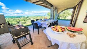 ein Esszimmer mit Tischen und einem Grill mit Aussicht in der Unterkunft Exclusive villa in Montefiascone -Pool and Jacuzzi in Montefiascone