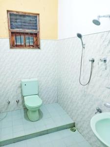 a bathroom with a toilet and a shower with a window at Fair View Bungalow in Kataragama