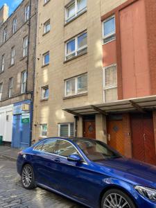 ein blaues Auto, das vor einem Gebäude parkt in der Unterkunft Private Main Door Lovely 2 bedroom apartment in Edinburgh