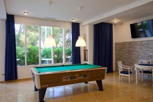 a room with a pool table and a dining room at Hotel Cala Murada in Cala Murada