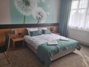 a bedroom with a bed and a chair in it at HOTEL PORT 2000 Torzym in Torzym